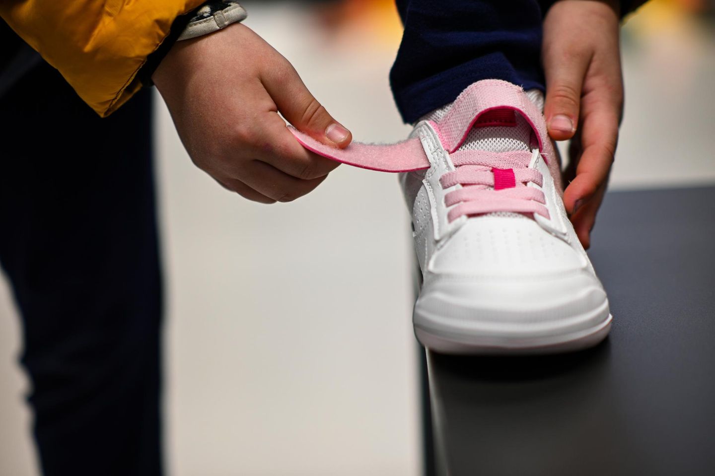 Person schließt Schuh mit Klettverschluss
