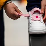 Person schließt Schuh mit Klettverschluss