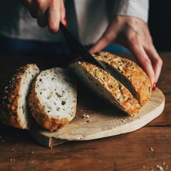 Eine Frau schneidet ein Brot