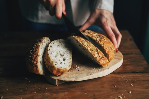 Eine Frau schneidet ein Brot