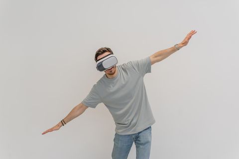 Person mit einer VR Brille simuliert, zu fliegen