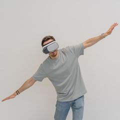 Person mit einer VR Brille simuliert, zu fliegen