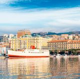 Schiff und Hafen von Rijeka vor bunten Hausfassaden