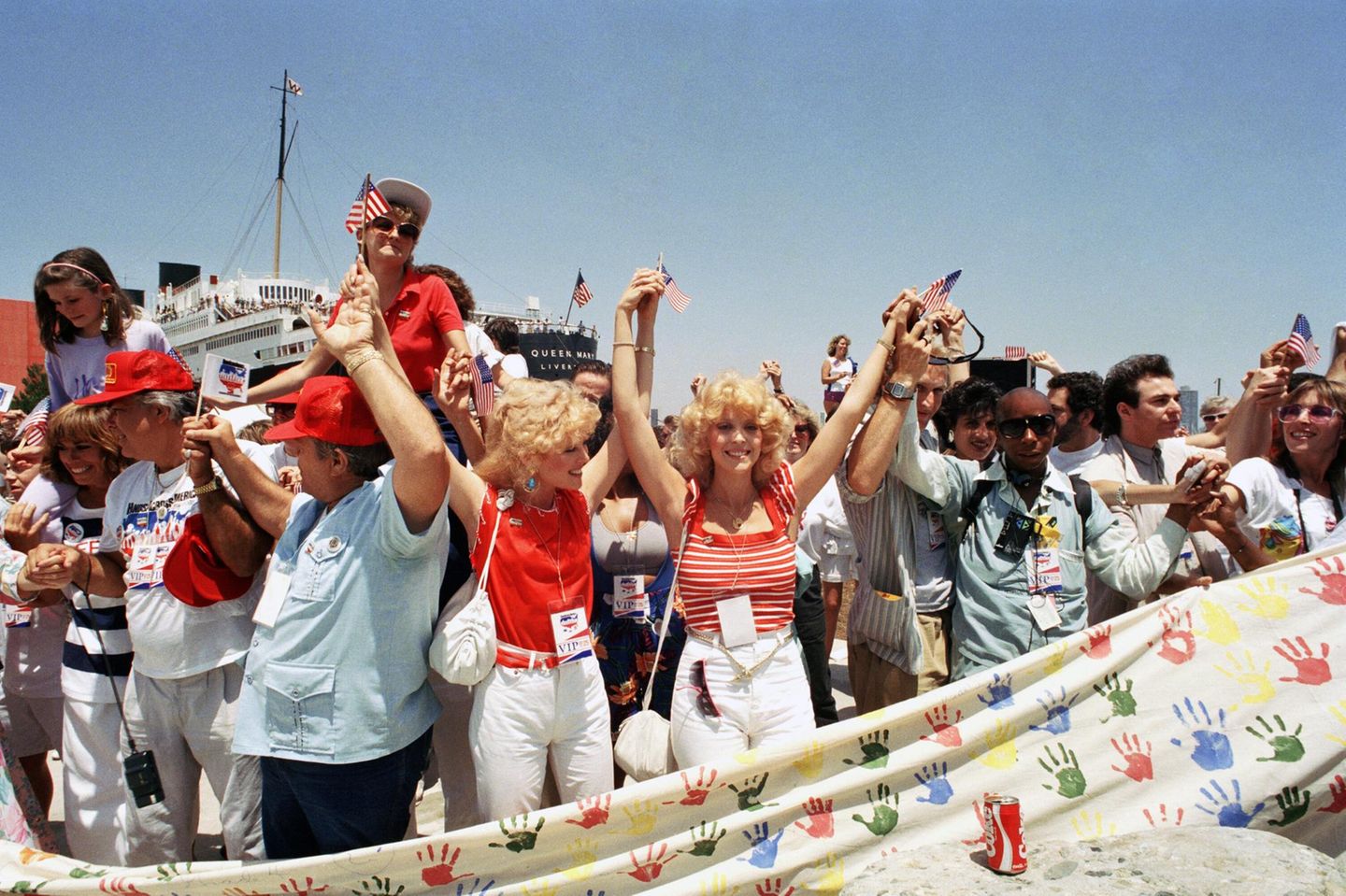Menschen halten bei einer Benefizaktion 1986 die Hände am Hafen von Long Beach hoch