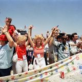Menschen halten bei einer Benefizaktion 1986 die Hände am Hafen von Long Beach hoch