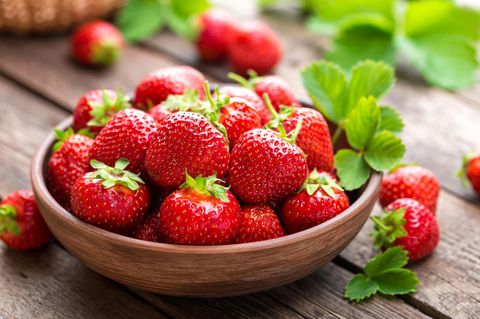 Frische Erdbeeren in Holzschale auf dem Gartentisch