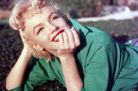 Marilyn strahlt in grünem Kleid - Kopf in die Hände gestützt