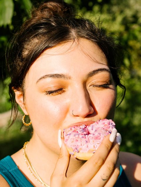 Eine Frau beisst in einen Doughnut