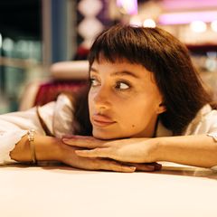 Eine Frau sitzt leicht gelangweilt in einem Diner